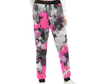 May include: Black, pink, and gray sweatpants with a splatter paint design. The sweatpants have a drawstring waistband and a relaxed fit.