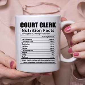May include: White ceramic mug with a black and white graphic of a nutrition facts label for a "Court Clerk". The label lists various qualities, such as "Hard Working", "Unrivaled Skill", and "Dedication", with percentages next to each. The text at the bottom of the label reads "* Not A Significant Source Of Gratitude Received. ** Percent Daily Values Are Based On Your Unique Diet."