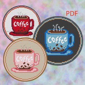 Könnte beinhalten: Drei Kreuzstichmuster von Kaffeetassen in Rot, Blau und Rosa. Auf jeder Tasse ist das Wort "Coffee" gestickt. Die Designs sind kreisförmig mit einem dekorativen Rand und Dampf, der aus dem Kaffee aufsteigt.