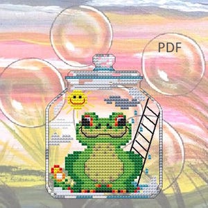 Pode incluir: Padrão de ponto cruz com um sapo verde dentro de um frasco de vidro com uma escada, sol e nuvens. O frasco está sobre um fundo colorido e desfocado com bolhas e o texto "PDF".