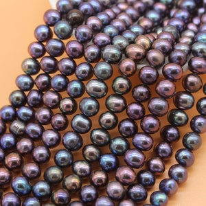 May include: A strand of iridescent black freshwater pearls. The pearls are round and smooth, with a slight sheen of color.
