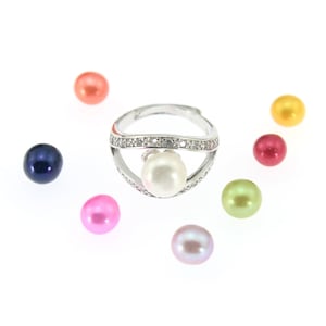 May include: A silver ring with a white pearl and clear stones, surrounded by colorful pearls in pink, red, green, blue, and orange.