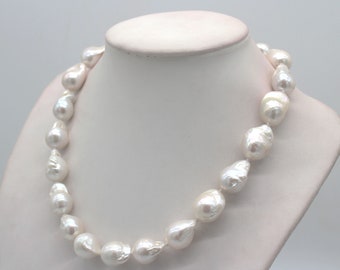 May include: A white baroque pearl necklace with large, irregular shaped pearls. The necklace is displayed on a white mannequin.