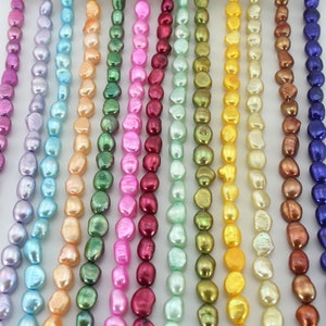May include: A strand of 12 different colored freshwater pearls. The pearls are all irregular in shape and have a slightly iridescent finish. The colors include purple, blue, light blue, peach, green, pink, red, light green, gold, yellow, brown, and blue.