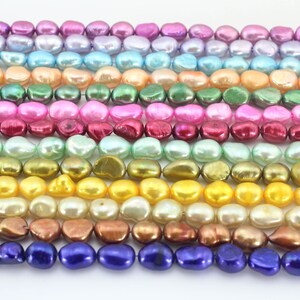 May include: A strand of iridescent baroque pearls in various colors, including pink, purple, green, yellow, and brown. The pearls are arranged in rows, with each row featuring a different color.