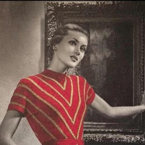 May include: A vintage-style image of a woman wearing a red top with gold chevron stripes. The top has short sleeves and a high neckline. The woman is posed in front of a framed artwork, with a classic hairstyle and makeup.