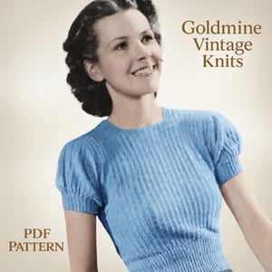 May include: A vintage-style, light blue knit top with short, puffed sleeves. The top has a ribbed texture and is part of a PDF pattern. The text "Goldmine Vintage Knits" is displayed on the image.