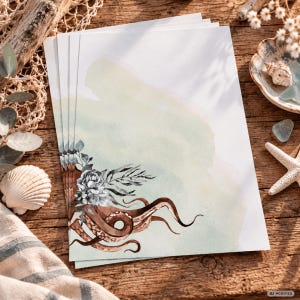 Könnte beinhalten: Ein Stapel rechteckiger Briefpapierbögen mit einer Aquarellillustration eines braunen Tintenfisch-Tentakels und grauen Blumenakzenten in der unteren linken Ecke, vor einem Hintergrund mit sanftem grün-weißem Farbverlauf auf dem Papier.