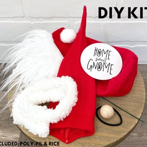 Puede incluir: Kit de bricolaje para gnomo con sombrero de fieltro rojo, barba de piel blanca, pomp&oacute;n blanco, nariz de fieltro blanco, nariz de madera, limpiapipas verde y un c&iacute;rculo blanco con el texto "Home Sweet Gnome".
