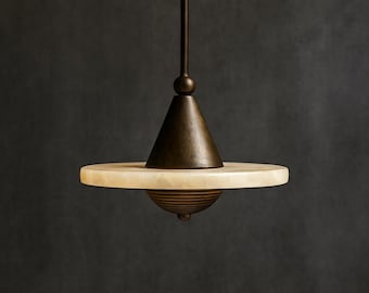 May include: A modern pendant light fixture with a bronze finish. The light features a conical top, a circular alabaster shade, and a decorative bottom element. The fixture hangs from a slender rod.