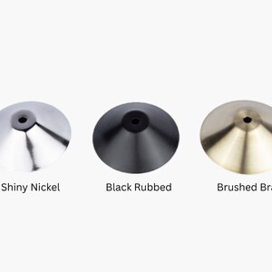May include: Three metal lamp finials in different finishes: shiny nickel, black rubbed, and brushed brass.