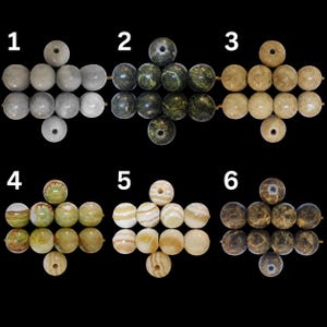 Peut inclure: Six groupes de perles sph&eacute;riques dispos&eacute;es en croix, num&eacute;rot&eacute;es de un &agrave; six. Le groupe un est gris clair, le deux vert fonc&eacute;, le trois beige, le quatre vert olive, le cinq cr&egrave;me avec des bandes, et le six brun fonc&eacute; avec des veines.