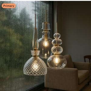May include: Three modern pendant lights with clear glass shades and brass-colored hardware. The shades have unique shapes, including a diamond-patterned dome and stacked spheres, each with a warm light bulb.