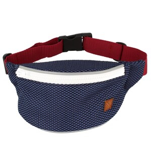 May include: A blue and white fanny pack with a red adjustable strap and a white zipper. The pack has a small brown leather patch with a logo.