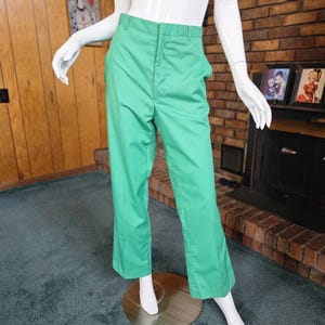May include: A pair of green wide-leg pants with a button fly and belt loops.