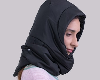 May include: A black hooded neck warmer with a quilted design. The neck warmer is made of a soft, warm material and is perfect for keeping your head and neck warm in cold weather.