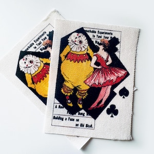 May include: Two fabric patches with a vintage circus theme. One patch features a clown in yellow and red, and a woman in a red dress. The other patch shows a clown. Text includes "Remarkable Experiments" and "Building a Face on Old Skull."