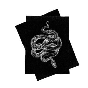 May include: Two black fabric patches with a white image of a snake coiled in a figure eight shape.
