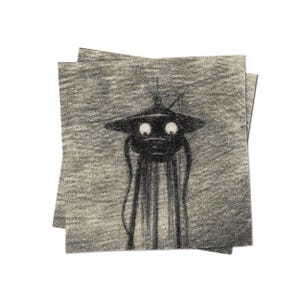 May include: A black and white illustration of a creature with large eyes and a hat, printed on a gray fabric coaster.