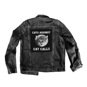 May include: Black denim jacket with a black and white patch on the back that says "Cats Against Cat Calls" and features a picture of a cat.