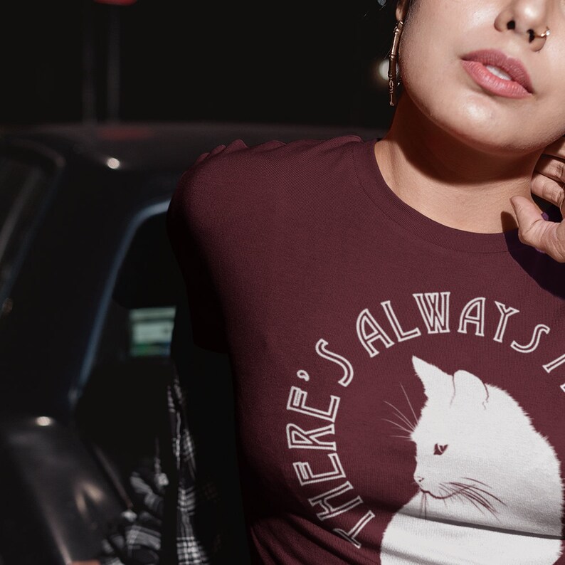 May include: A maroon t-shirt with a white graphic of a cat and the text "There's always a cat for that".