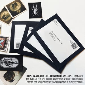 May include: Three black envelopes with white address labels. The labels include a name, address, and a QR code. The text on the label reads "YOUR FIRST LAST, 123 HOME AVE APT 29, YOUR STATE, SE 12345". The envelopes are stacked on top of each other. The text "SHIPS IN A BLACK GREETING CARD ENVELOPE. UPGRADES ARE AVAILABLE IF YOU PREFER A DIFFERENT SERVICE. CHECK YOUR LETTERS FOR YOUR DELIVERY. TRACKING WORKS IN THE ETSY ORDER." is printed below the envelopes.