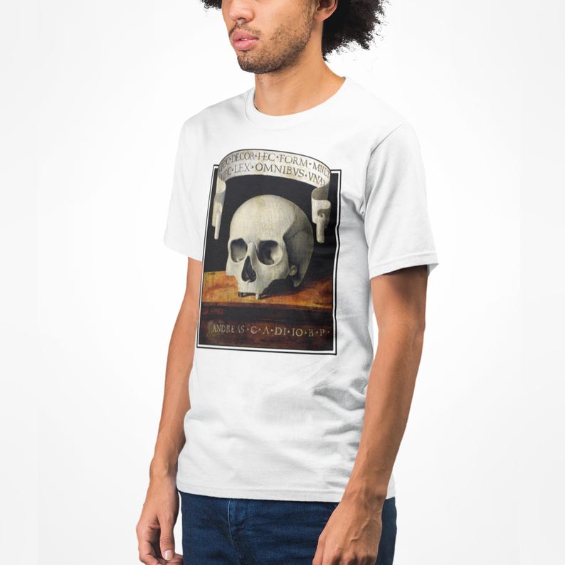 K&ouml;nnte beinhalten: Wei&szlig;es T-Shirt mit einer detaillierten Sch&auml;delillustration im klassischen Malstil, mit lateinischem Text. Das T-Shirt hat einen Rundhalsausschnitt und kurze &Auml;rmel.