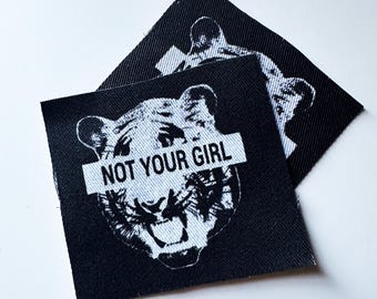 Könnte beinhalten: Schwarz-weißes Bügelbild mit einem Tigergesicht und dem Text "NOT YOUR GIRL" über den Augen.