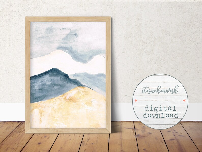 May include: Abstract watercolour landscape print in a light wood frame. The artwork depicts mountain shapes in blue, white, and gold. The print is a digital download, as indicated by the text on the image.