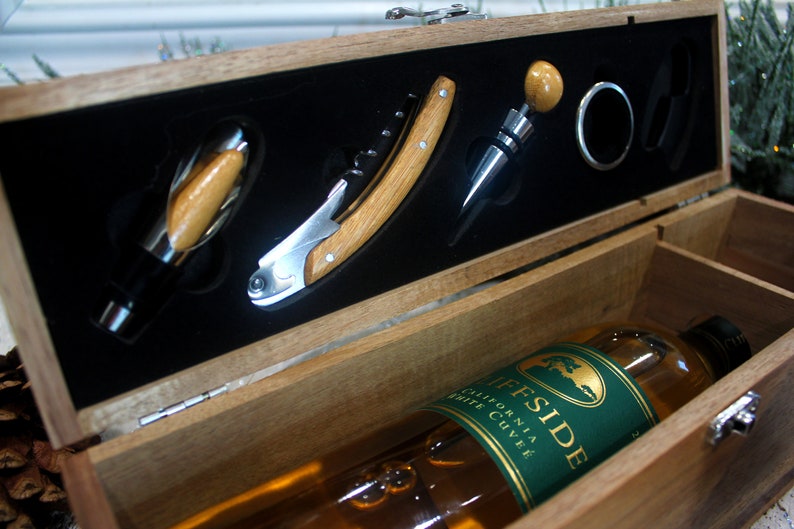 K&ouml;nnte beinhalten: Eine Holzkiste mit einer Flasche Wein und einem Weinkorkenzieher-Set. Die Kiste ist ge&ouml;ffnet und das Weinkorkenzieher-Set ist sichtbar. Die Weinflasche ist mit "Cliffside California White Cuvee" beschriftet.