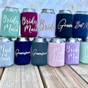 May include: Twelve beverage insulators with various wedding party titles printed on them. The titles include "Bride", "Groom", "Maid of Honor", "Bridesmaid", and "Groomsman".