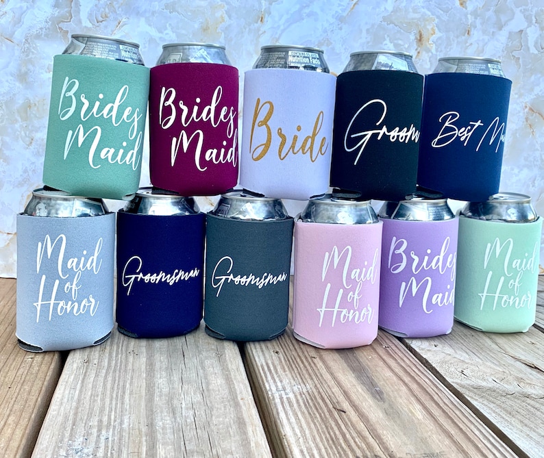 May include: Twelve beverage insulators with various wedding party titles printed on them. The titles include "Bride", "Groom", "Maid of Honor", "Bridesmaid", and "Groomsman".