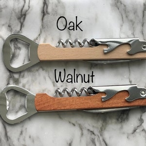 May include: Two wooden handled bottle openers with corkscrews. The top opener has a light wood handle labeled "Oak" and the bottom opener has a darker wood handle labeled "Walnut".