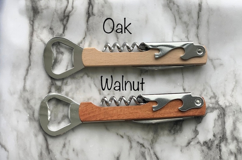 May include: Two wooden handled bottle openers with corkscrews. The top opener has a light wood handle labeled "Oak" and the bottom opener has a darker wood handle labeled "Walnut".