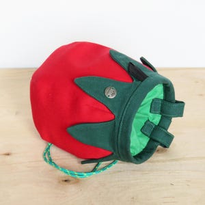 red tomato shape with dark green leaves chalk bag for climbing in rock and gym, closing