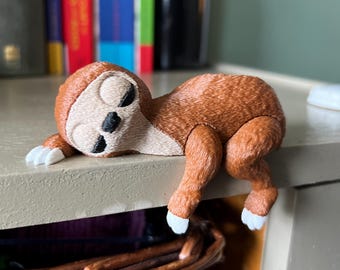 眠っているナマケモノの棚飾り、本棚用のかわいい茶色のナマケモノの 