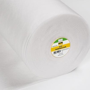 Puede incluir: Un rollo de tela Thermolam blanca. La etiqueta dice "272 THERMOLAM" e incluye medidas de 90 cm x 25 m. La tela está enrollada firmemente, mostrando la textura del material. El rollo está sobre un fondo blanco.