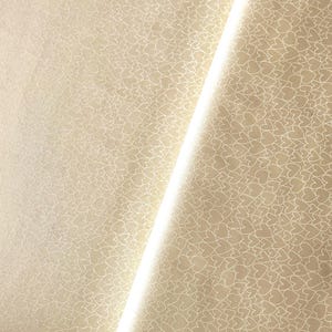 Puede incluir: Papel de regalo color crema con un patrón repetido de corazones blancos. El papel está doblado, creando una línea diagonal de luz en la imagen. Los corazones son pequeños y están espaciados uniformemente.