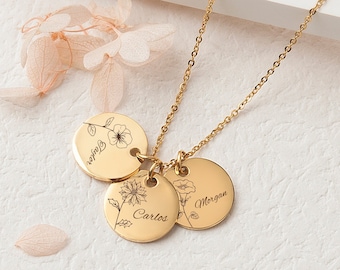 May include: Gold necklace with three round pendants featuring delicate floral designs and the names "Morgan", "Carlos", and "Taylor".