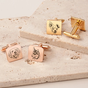 May include: Four pairs of square cufflinks with dog portraits. Two pairs are rose gold, featuring a Golden Retriever and a Husky. The other two pairs are gold, with a Chihuahua portrait. The cufflinks are displayed on a textured, light-colored surface.