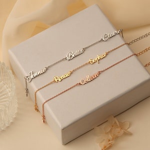 May include: Four delicate silver and gold nameplate necklaces with the names "Jennie", "Bella", "Sophia", "Claire", "Renae", and "Colleen" on them.