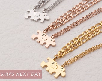 May include: Three gold, silver, and rose gold necklaces with puzzle piece pendants. Each puzzle piece has two letters engraved on it. The necklaces are on a white surface. Ships next day.