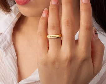 May include: Gold band ring with the name "Isabella" engraved on it.