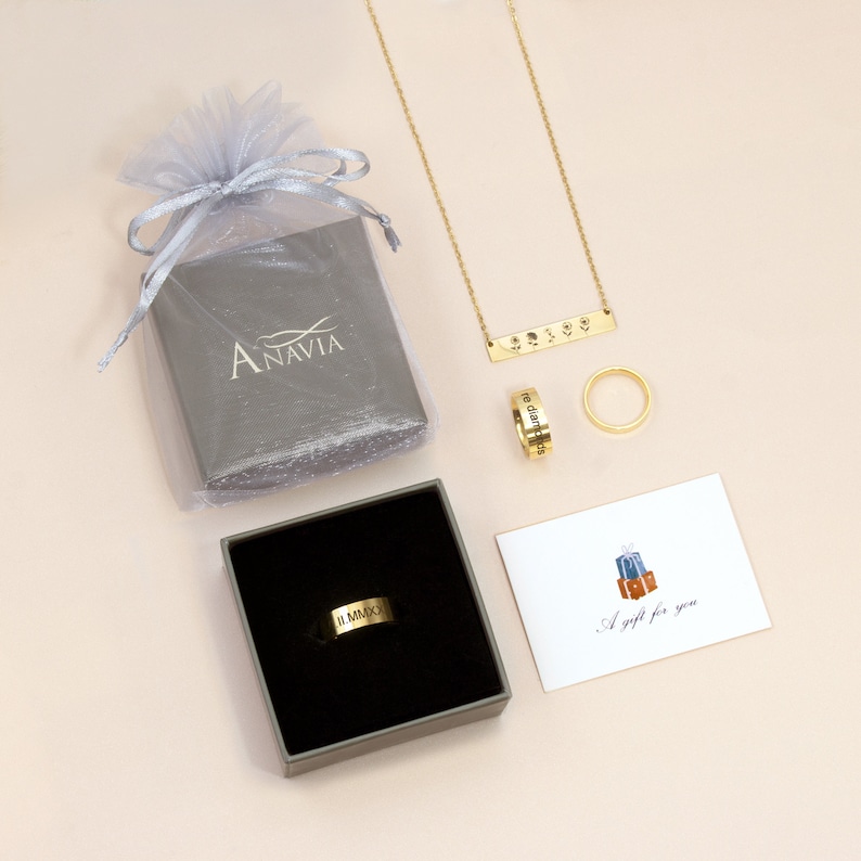 May include: A gold necklace with a bar pendant that says "the diamonds are forever". The necklace is in a gray box with a white ribbon. There is also a gold ring with the inscription "the diamonds are forever" and a smaller gold ring. A card with the text "A gift for you" is also included.