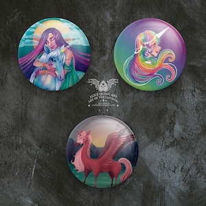 May include: Three round pinback buttons with colorful illustrations of mythical creatures. The first button features a woman with long purple hair holding a white unicorn. The second button features a woman with long rainbow hair. The third button features a pink winged horse.