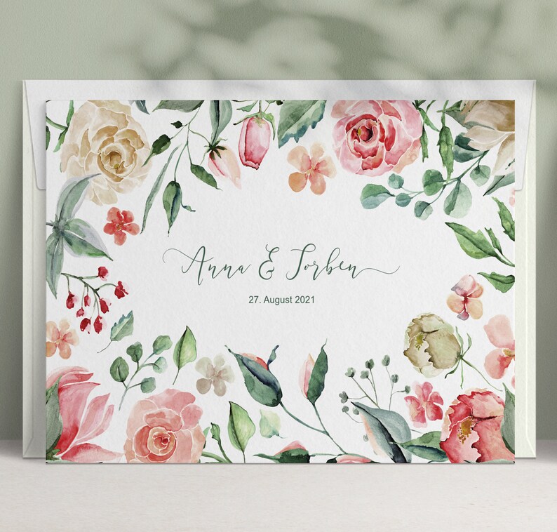 May include: A white wedding invitation with a watercolour floral border. The text reads "Anna & Torben" and "27. August 2021".