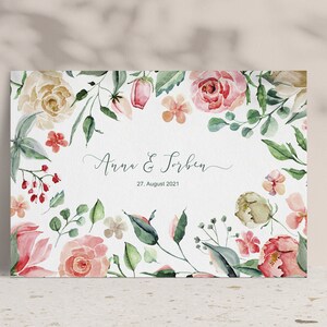 May include: A watercolour wedding invitation with a floral border. The invitation features pink, white and green flowers and leaves. The text on the invitation reads "Anna & Torben" and "27 August 2021".