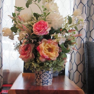 Rosa Rosen in Delft Keramikbehälter mit weißen Wildblumen und viel Grün