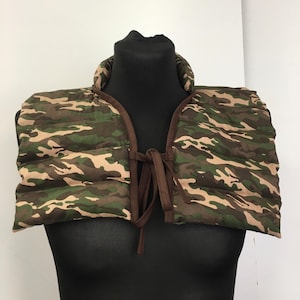 Può includere: Un collo di pelliccia con motivo mimetico e lacci marroni. Il collo è realizzato in tessuto trapuntato ed è progettato per fornire calore e comfort intorno al collo.