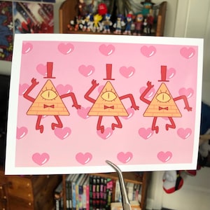 May include: Three cartoon illustrations of Bill Cipher from the show Gravity Falls. Each illustration is a yellow triangle with a single eye, a red bow tie, and a top hat. The background is pink with a pattern of pink hearts.